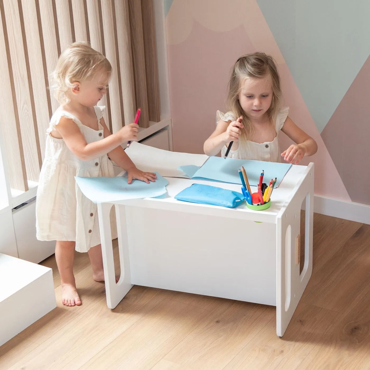 Zwei Mädchen am weißen KiddyMoon Kindertisch im hellen Kinderzimmer